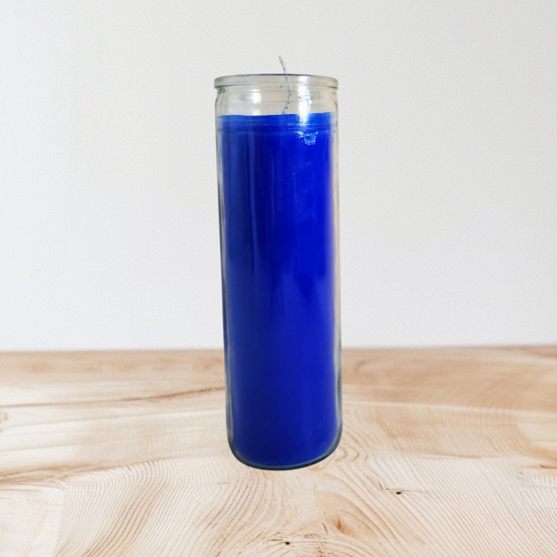 Tall deep blue 7-day candle standing on a wooden table with a warm beige backdrop.
