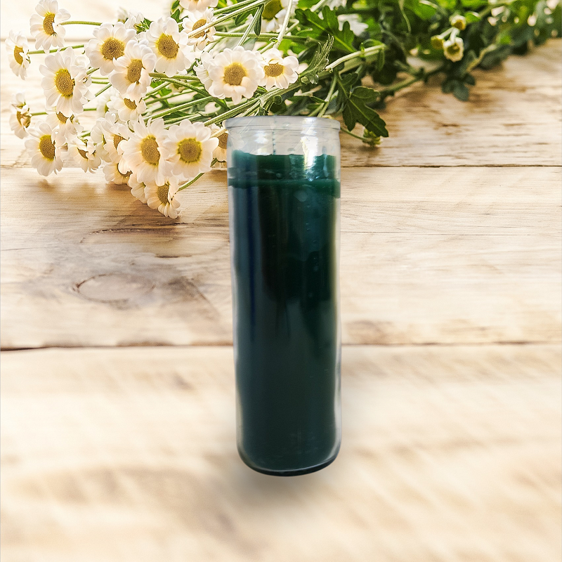 Green ritual candle centered on a light wooden table beside a small flower bouquet, creating a soft, serene, regal ambiance.