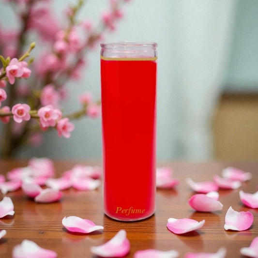 Vibrant red 7-day candle in a glass jar on wood table, surrounded by pink rose petals and soft blossom branches.